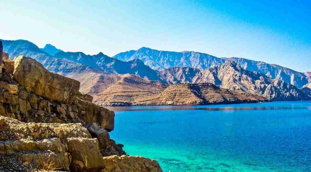 Tourists enjoying snorkeling and swimming in the clear turquoise waters of Musandam Dibba.